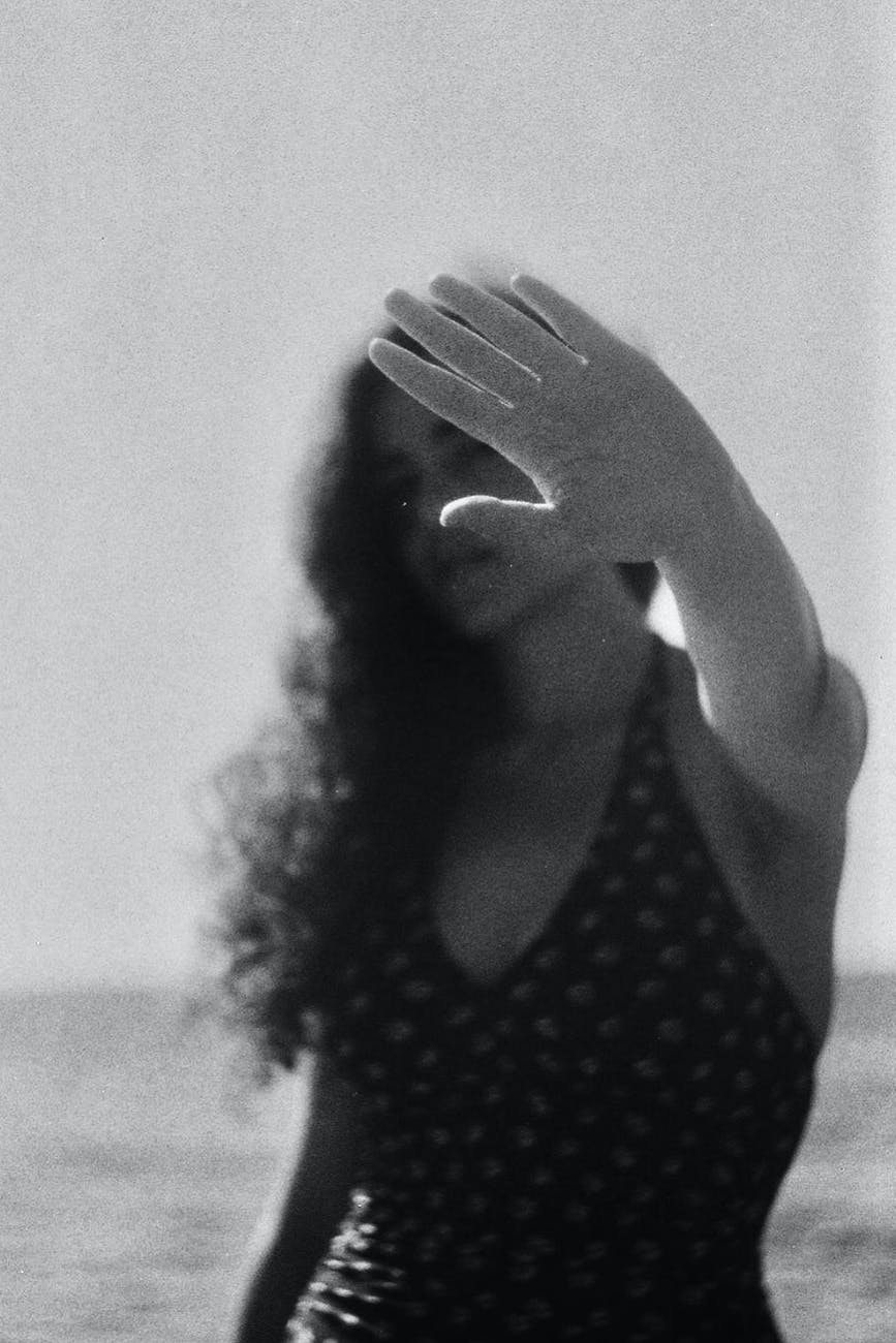 woman showing stop gesture against sea in sunshine