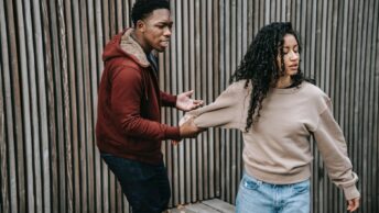 aggressive black man grabbing offended ethnic woman